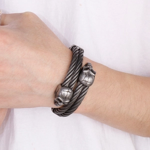Macro detail of retro skull heads on a twisted wire stainless steel cable bracelet