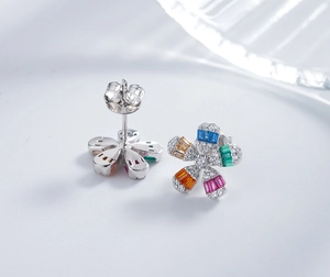 Macro shot of silver daisy earrings featuring multi-color stones and micro-pave crystals