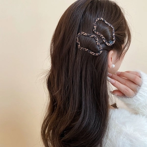Dettaglio di fermagli per capelli con stampa leopardata su capelli lunghi mossi alla moda
