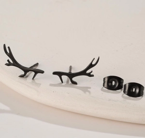 Close-up of matte black antler studs made of stainless steel on white pedestal