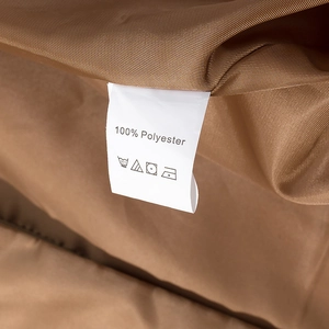 Macro shot of 100% polyester material label on khaki double-breasted trench coat