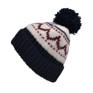 Détail du motif en tricot jacquard rétro et du pompon sur un bonnet d'hiver chaud