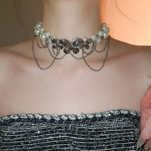 Detail of double-layer pearl choker featuring silver butterfly pendants and tassels