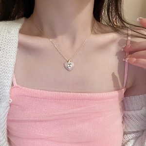 Close-up of pink enamel heart pendant necklace with zircon stone on a model's neck