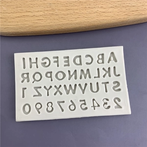 White silicone alphabet and number mold for baking and DIY crafts on a purple background