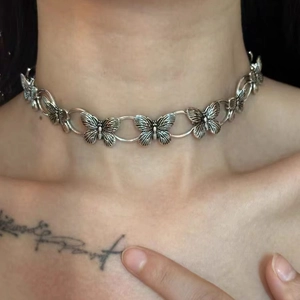 Close-up of Y2K silver butterfly choker with interlocking metal rings on model