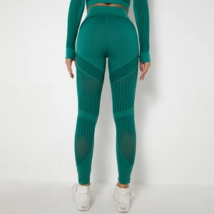 Detail of dark green seamless yoga pants with mesh stripe cut-outs and booty lifting seam