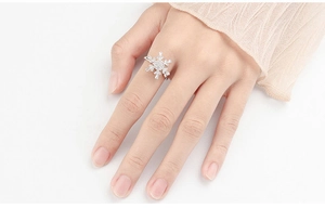 Close-up of silver snowflake spinner ring with zircon stones worn on finger