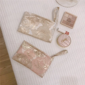 Detailed close-up of champagne and pink rose jacquard mini bags with gold thread texture