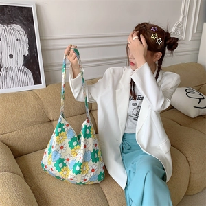 Detail of floral canvas tote bag showing large capacity and vibrant pattern on a sofa