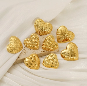 Detailed macro view of gold heart earrings with four distinct vintage textures and patterns
