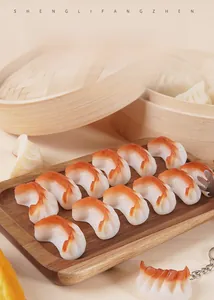 Realistic PVC fried dumpling model with golden texture on a wooden tray with a keychain