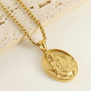 Gros plan du collier avec pendentif relief en or 18k sur un socle en pierre beige