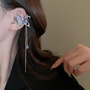 Detail of silver butterfly ear cuff with purple wings and long tassel on model