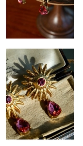 Macro detail of vintage sunburst earrings with pink teardrop gemstones in gold finish