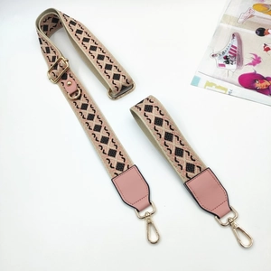 Detail of adjustable geometric strap with pink leather ends and gold metal buckles