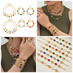 Conjunto de joyas doradas con eslabones huecos y piedras ovales de colores variados