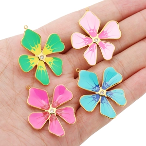 Four colorful enamel five-petal flower pendants with gold plating and sparkling rhinestones