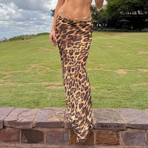 Detail of high-waist leopard print mesh skirt with sheer fabric and gold waist chain