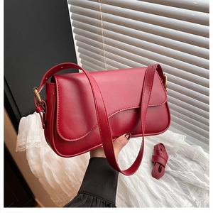 Detail shot of vintage burgundy leather handbag with detachable shoulder strap accessory