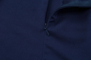 Détail de la fermeture éclair invisible et texture du tissu bleu marine sur la robe