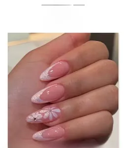 Detail of pink French almond press-on nails with white flower patterns and glitter edges