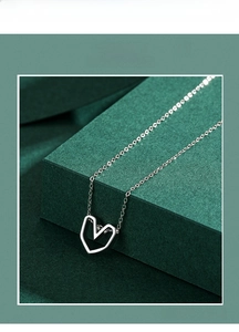 Detail of minimalist S925 silver necklace featuring a hollow heart-shaped pendant