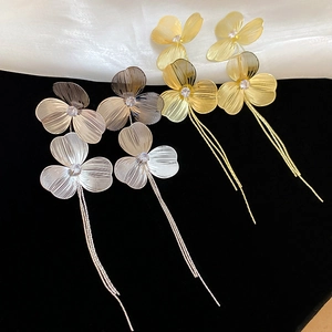 Detail of flower tassel earrings with zircon center and metallic petal textures