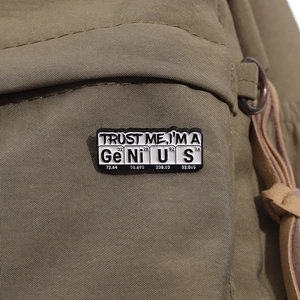 Enamel pin badge featuring Trust Me I am a Genius spelled with chemical elements