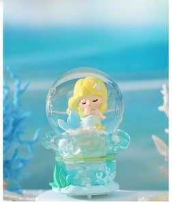 Detail view of a glowing ocean mermaid crystal ball with seaweed and coral decor