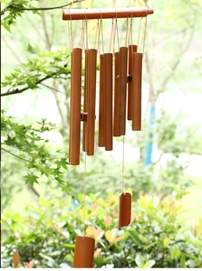 Detailed view of natural brown bamboo wind chime tubes with rustic wooden pendants