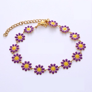 Gros plan détaillé du bracelet en chaîne dorée avec des breloques marguerites violettes