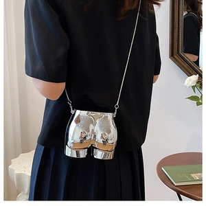 Detailed close-up of a silver mirror-effect hip-shaped crossbody bag with a slim chain