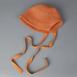 Detailed knit texture of orange toddler bonnet with breathable crochet patterns