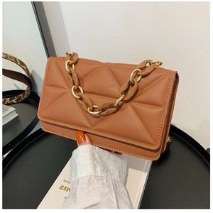 Close-up of brown quilted leather handbag with chunky chain handle and gold buckle detail