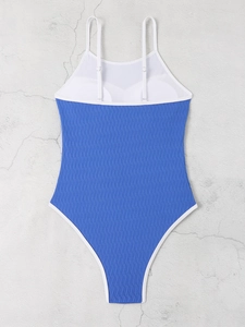 Detailed view of blue wavy texture fabric on backless one-piece swimsuit with white straps