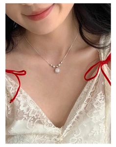 Detail of S925 sterling silver necklace with pink square zirconia on white lace dress