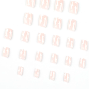 Press-on nail set with nude pink and white heart patterns on a clean white background