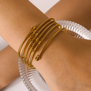 Bracciale dorato multistrato in filo metallico intrecciato con terminali a sfera al polso
