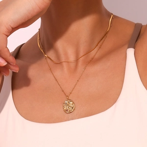 Detail of 18K gold-plated double-layer necklace with celestial pendant on a female model