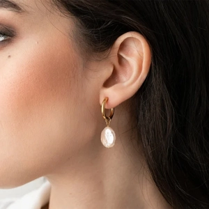 Close-up of 18K gold stainless steel hoop earring with baroque pearl drop on model