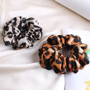 Vintage leopard print silk scrunchies in brown and grey tones on soft fabric background