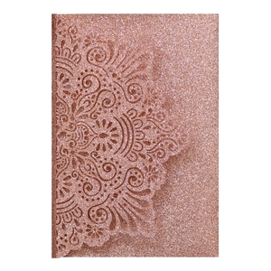 Detail of rose gold glitter laser-cut wedding invitation with intricate mandala patterns