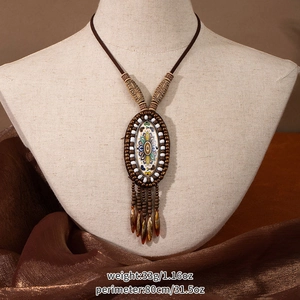 Detail view of Bohemian mandala pendant with tassels and beads on jewelry display stand