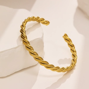 Detailed view of the 18k gold plated twisted spiral cuff bracelet with polished finish