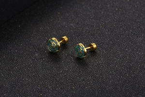 Detail of gold rose earrings with blue enamel and secure flat screw back design