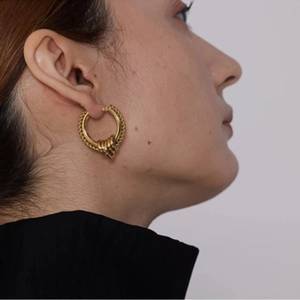 Elegant gold twisted hoop earrings with textured thick bands for a stylish feminine look