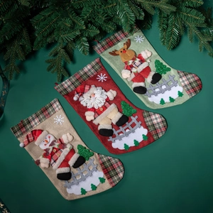 Trois chaussettes de Noël avec Père Noël, bonhomme de neige et renne sur fond vert