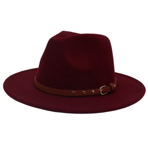 Detail of burgundy wool fedora featuring a brown leather band with gold rivets