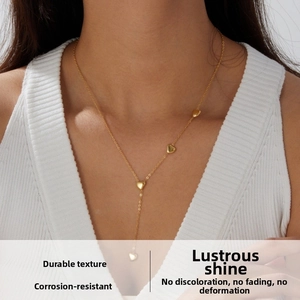 Close-up of golden Y-shaped heart pendant necklace worn on a woman with a V-neck top
